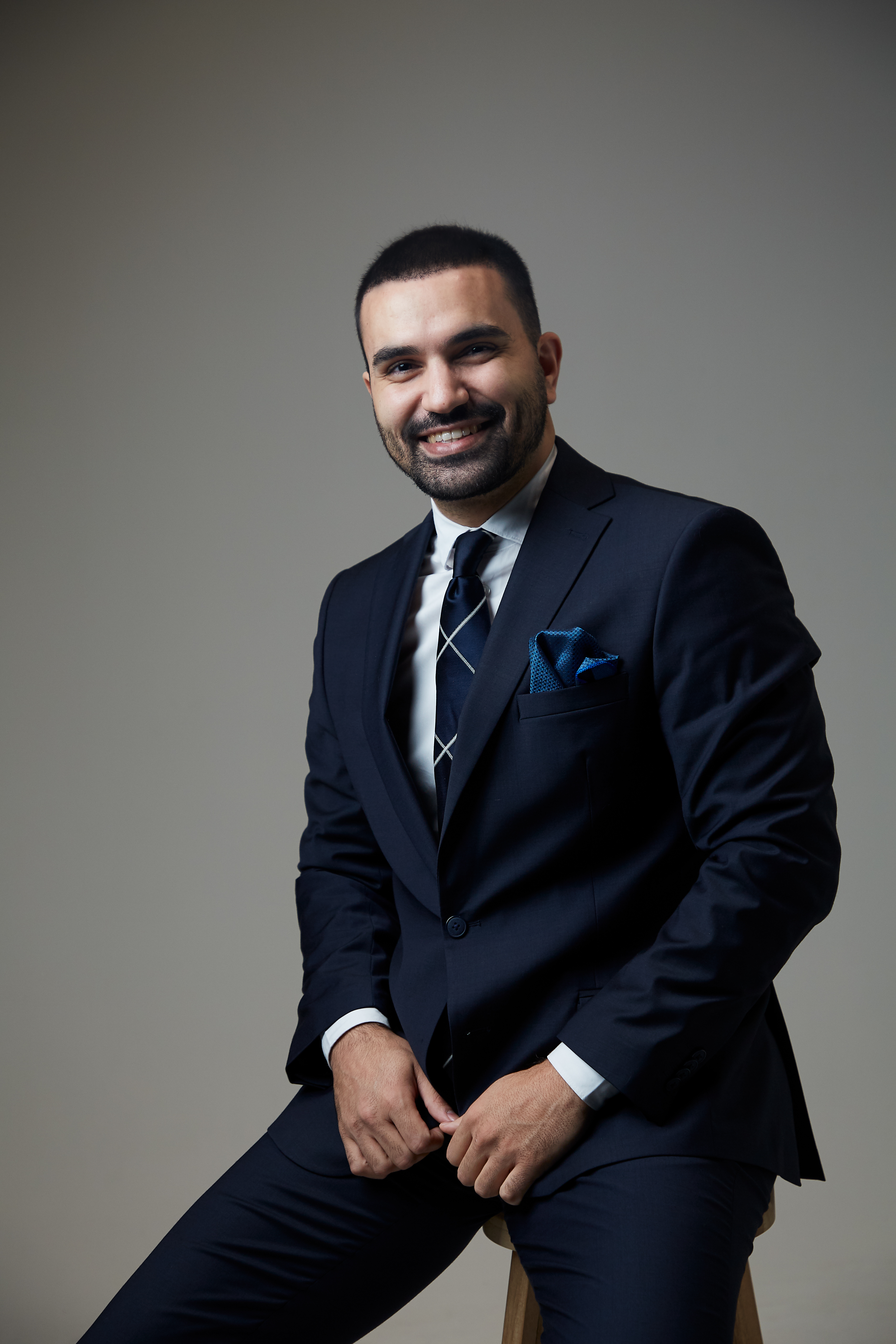 Kenan Lenny Aktas, souriant, en costume bleu marine